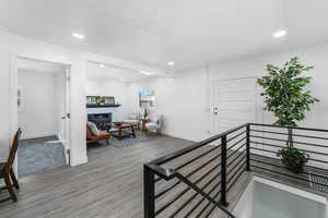 Hall featuring recessed lighting, wood finished floors, an upstairs landing, and baseboards