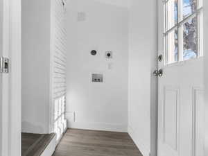 Hall with lofted ceiling, baseboards, and wood finished floors