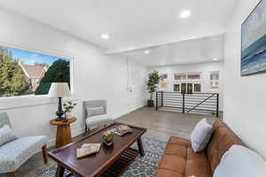 Living room featuring recessed lighting, wood finished floors, and a healthy amount of sunlight