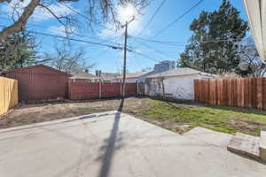 View of yard with a patio area, a fenced backyard, and an outbuilding