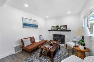 Living area with recessed lighting, visible vents, baseboards, and wood finished floors