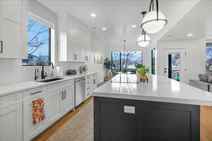 Kitchen with dishwasher, a healthy amount of sunlight, a sink, and a notable chandelier