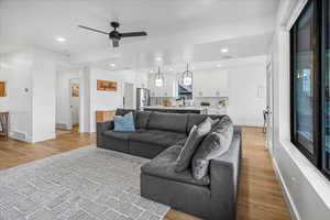 Living area featuring baseboards, light wood-style flooring, visible vents, and recessed lighting