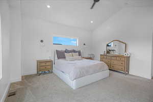 Bedroom featuring carpet floors, visible vents, baseboards, and vaulted ceiling