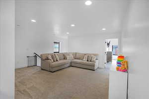 Living room featuring recessed lighting, baseboards, and light colored carpet