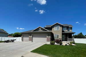 View of front of property with driveway, an attached garage, stucco siding, brick siding, and a porch