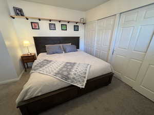 Carpeted bedroom featuring a closet and baseboards