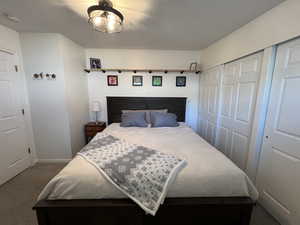 Bedroom with baseboards, dark carpet, and a closet