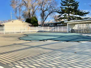 Pool with a patio area and fence