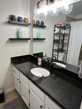 Full bathroom featuring baseboards, vanity, a shower with shower curtain, and tile patterned floors