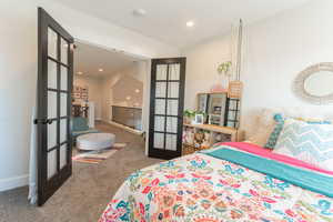 Carpeted bedroom 1  with French doors.