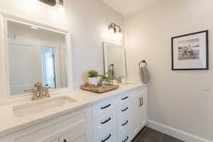 Bathroom with double vanity, and tile patterned flooring.