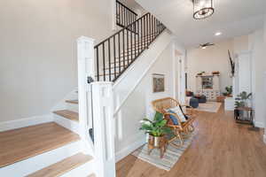 Beautiful staircase just beyond the living room and leading to the loft. Featuring  wood finished floors