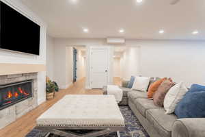 Living room with a fireplace, wood finished floors, and recessed lighting