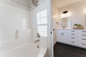 Full bath featuring tub / shower combination, vanity, and tile patterned floors