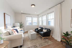 Living area featuring recessed lighting, wood finished floors, and custom windows.