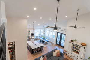 Living area featuring ceiling fan, light wood-style flooring, recessed lighting, vaulted ceiling, and french doors to the patio.