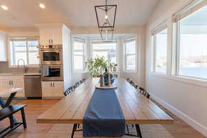 Dining room featuring recessed lighting, a chandelier, and light wood-style floors. Visible in the Kitchen are professional grade double ovens.