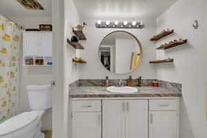 Full bath featuring vanity, toilet, and a textured ceiling
