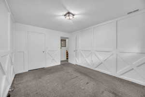 Garage with a decorative wall and visible vents