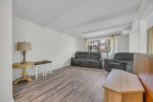 Living room featuring wood finished floors and beamed ceiling