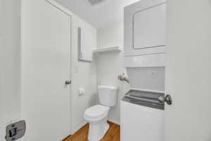 Bathroom with toilet, wood finished floors, a textured ceiling, visible vents, and baseboards