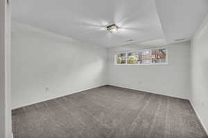 Carpeted spare room featuring baseboards and visible vents