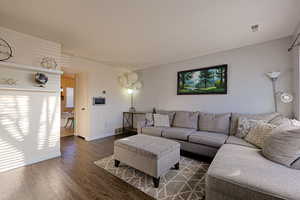 Living room with wood finished floors, visible vents, and baseboards