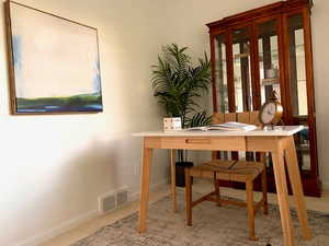 Carpeted office featuring visible vents and baseboards
