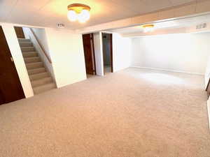 Finished basement featuring baseboards, carpet, stairs, and visible vents