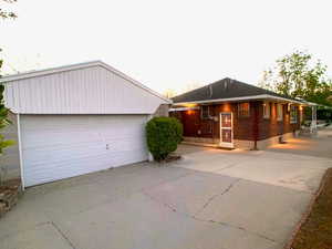 View of front of property with a detached garage and brick siding