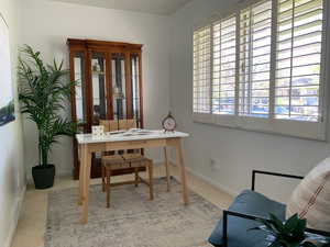 Carpeted home office featuring baseboards