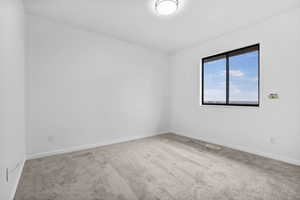 Empty room featuring carpet flooring and baseboards