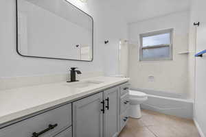 Bathroom with toilet, vanity, shower / washtub combination, and tile patterned floors