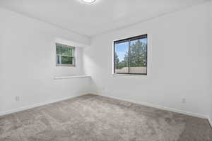 Empty room featuring carpet floors, baseboards