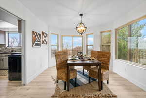 Dining room featuring a chandelier, baseboards, and light wood finished floors