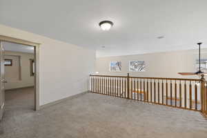 Unfurnished room with carpet, baseboards, and ceiling fan
