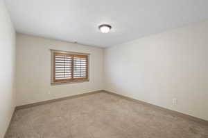 Carpeted empty room featuring baseboards