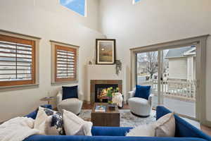 Living room with a healthy amount of sunlight, wood finished floors, and a tile fireplace