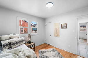 Bedroom with light wood-style floors, multiple windows, and baseboards