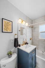 Bathroom with shower / washtub combination, vanity, and toilet