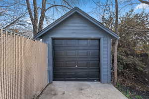 Detached garage with fence and concrete driveway