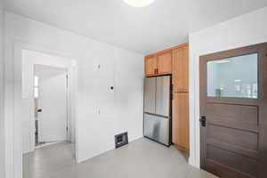 Kitchen with freestanding refrigerator and visible vents