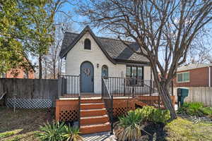 Tudor-style house featuring fence, a deck, and brick siding