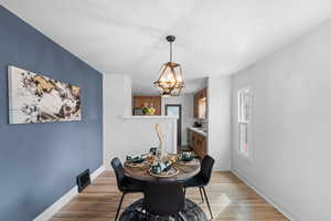 Dining space featuring light wood finished floors, an inviting chandelier, and baseboards