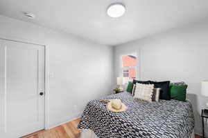 Bedroom featuring baseboards and wood finished floors