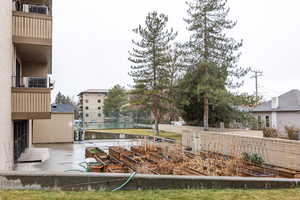 View of yard featuring a balcony, fence, and a vegetable garden