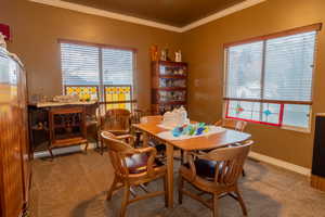 Dining room with carpet floors, plenty of natural light, and crown molding