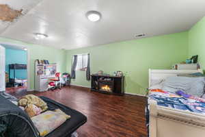 Bedroom featuring a fireplace, baseboards, and wood finished floors