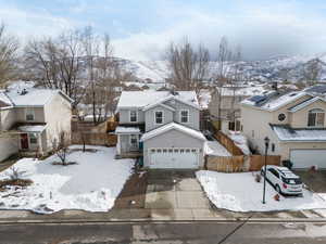 Traditional home with driveway, an attached garage, fence, and a residential view